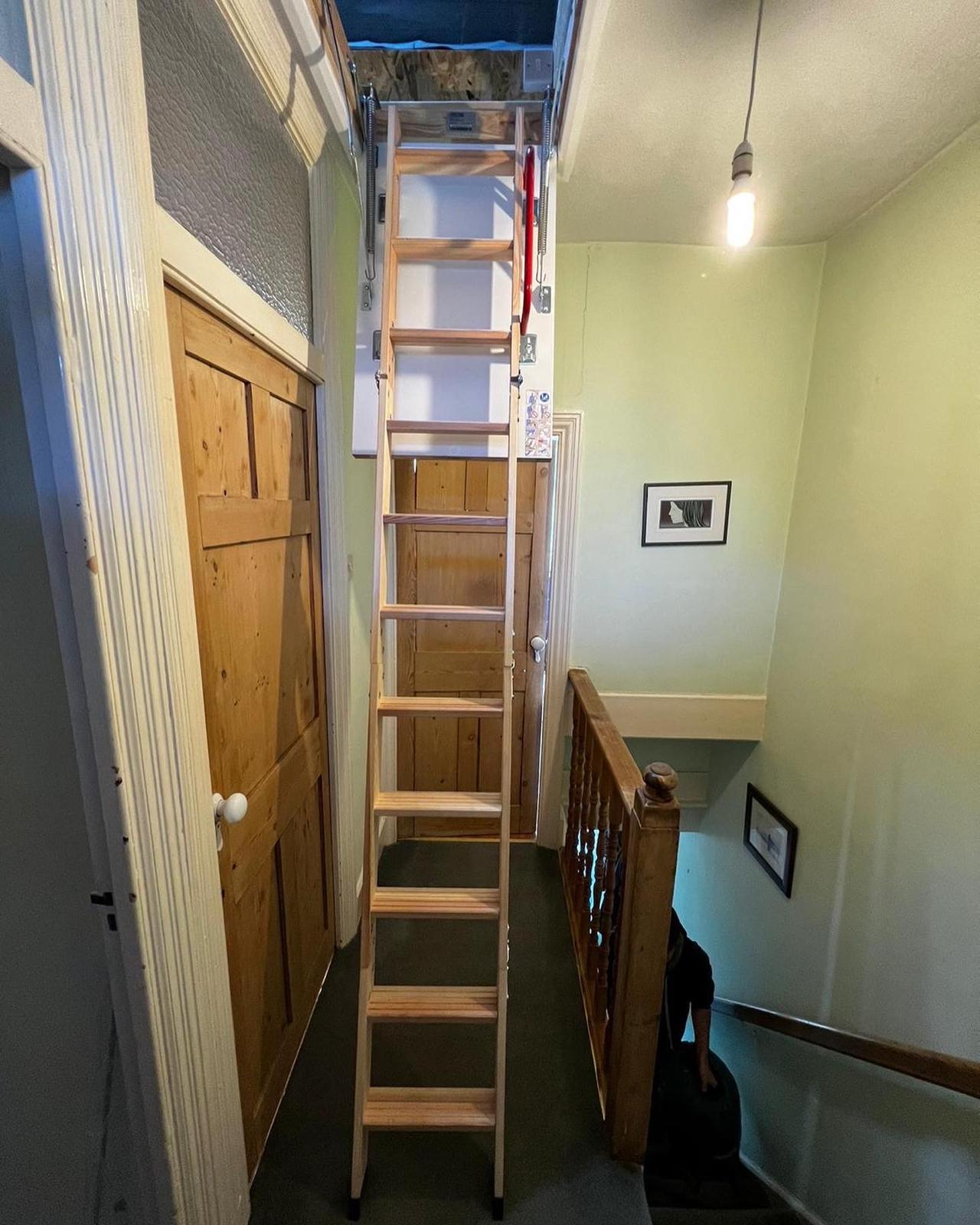 Timber loft ladder installed onto a landing by TG Loft Boarding